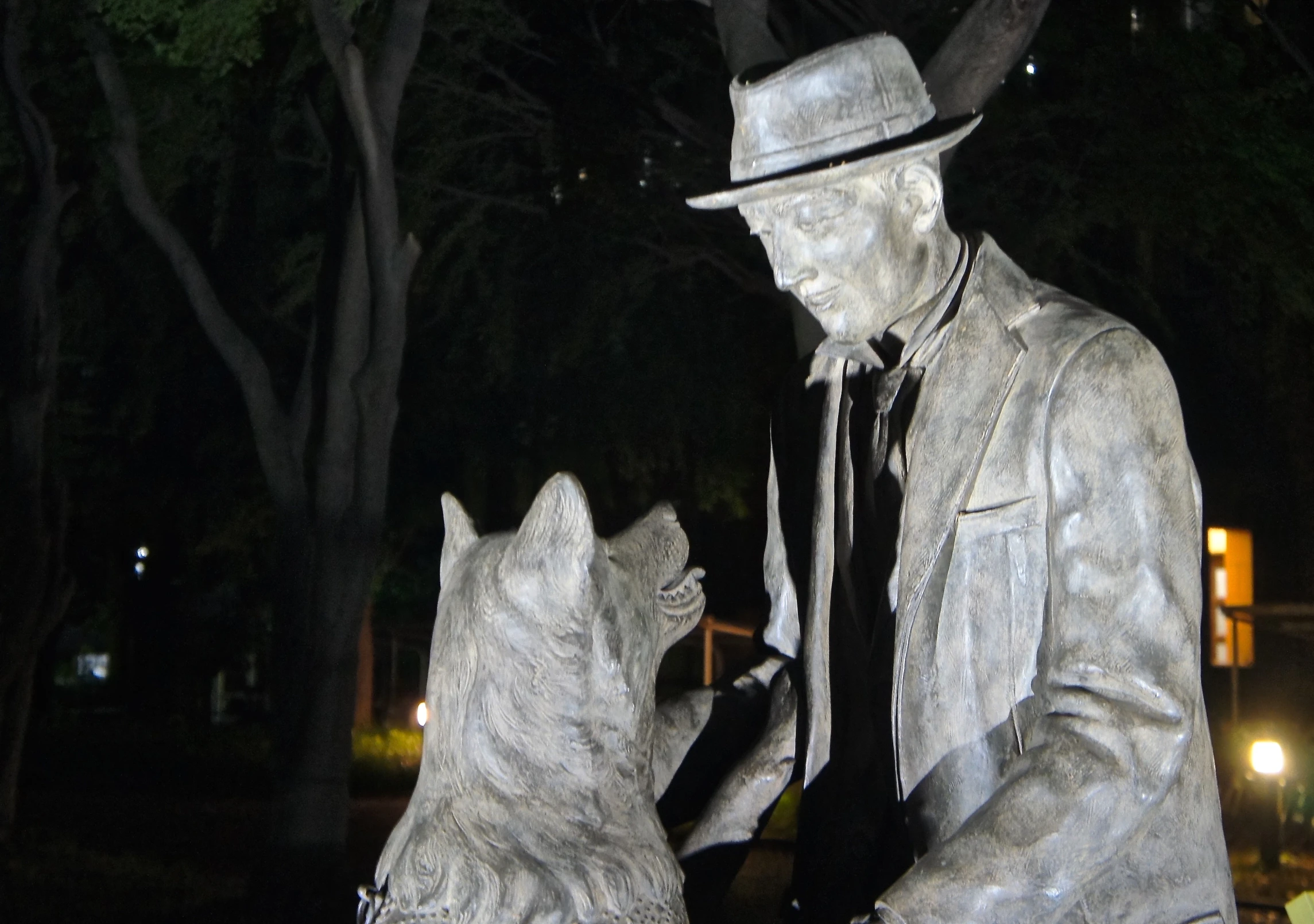 the statue of a man and dog is in the dark