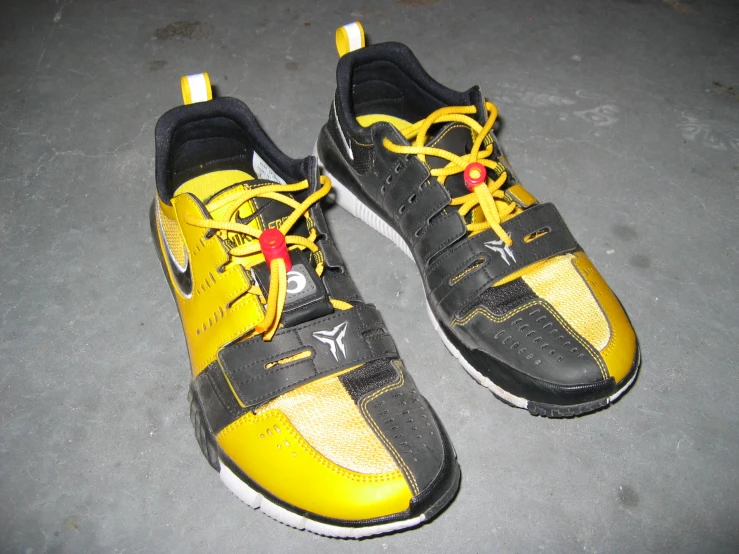 a yellow and black pair of shoes on the ground