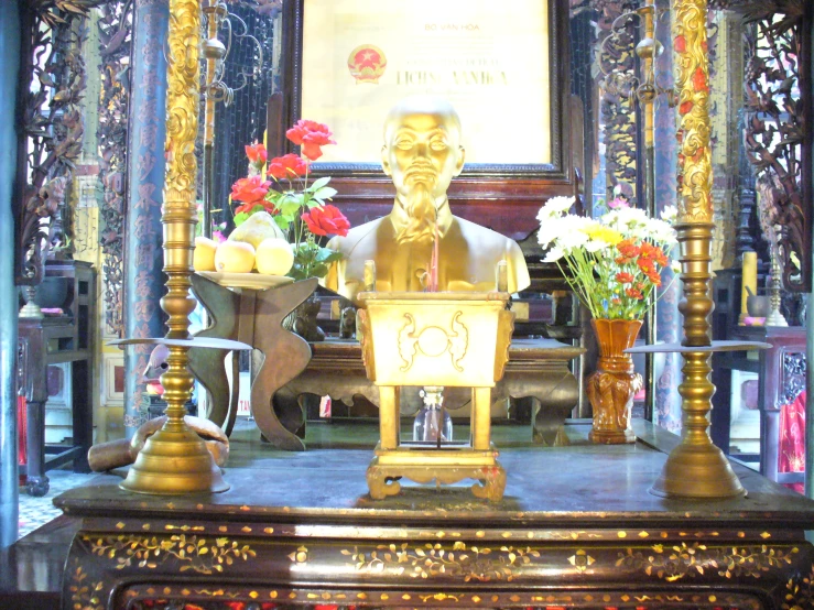 a busturistature sits in front of a golden alter