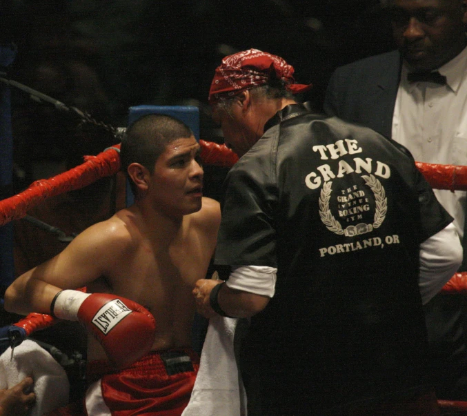 a man standing next to a referee holding a ring