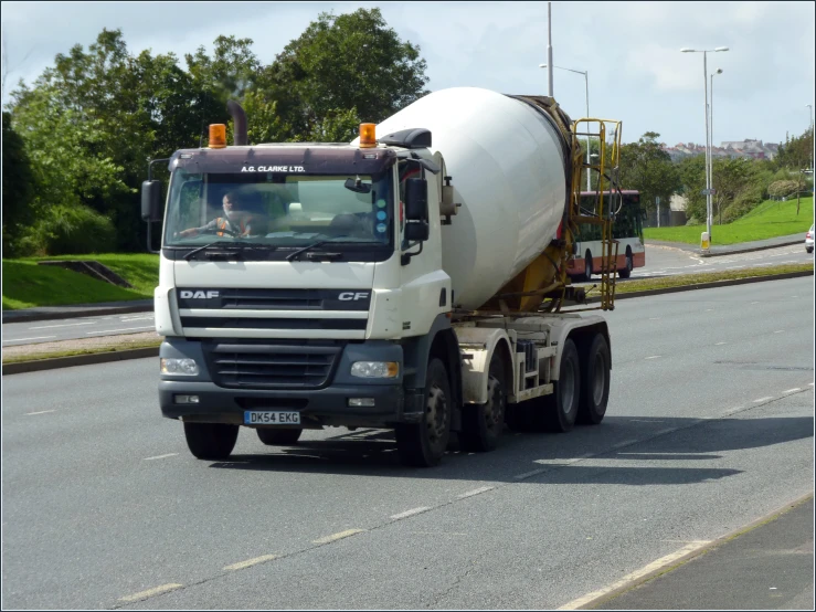 a cement truck traveling down a road past some houses