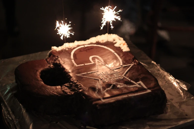 a chocolate birthday cake with fireworks going from top