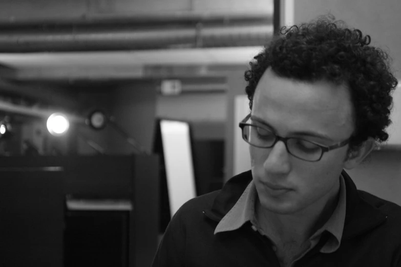 a man with curly hair sitting in an office