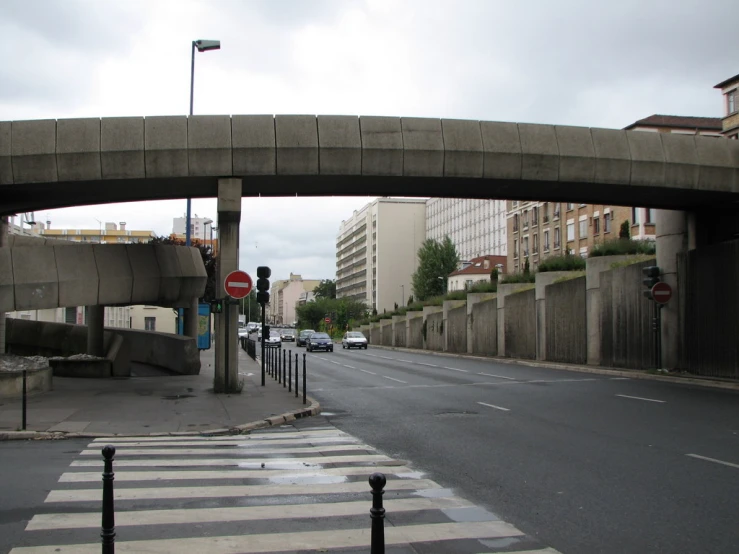 an empty street with cars on both sides, some cars at the end