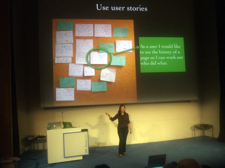 a woman is presenting a presentation on a large screen