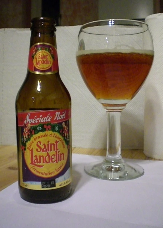 a glass of beer on a table near a bottle