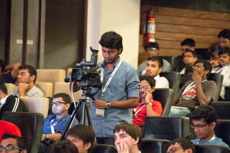 an audience in an auditorium is watching someone taking a po