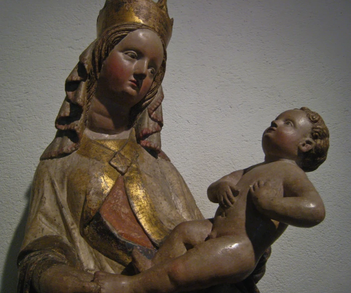 a statue has a baby beside it with gold trim