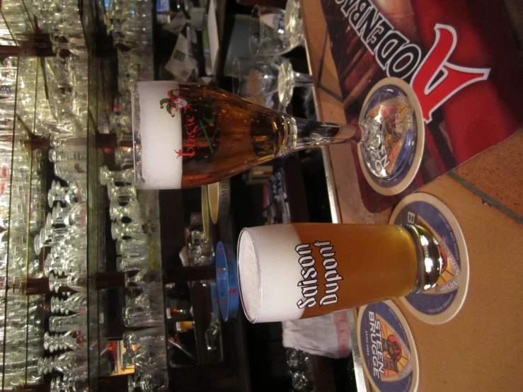 two glasses of beer sit on the bar in a bar