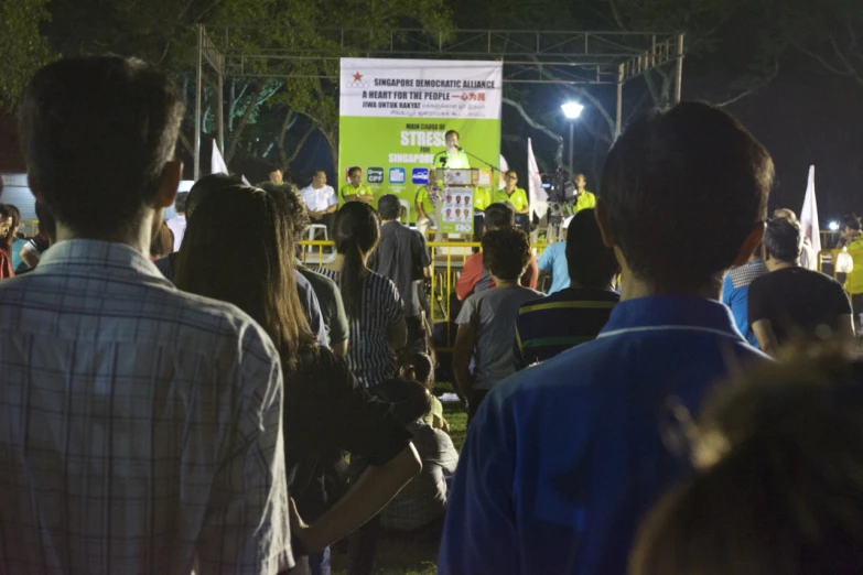 a crowd is gathered around the speaker during the outdoor concert