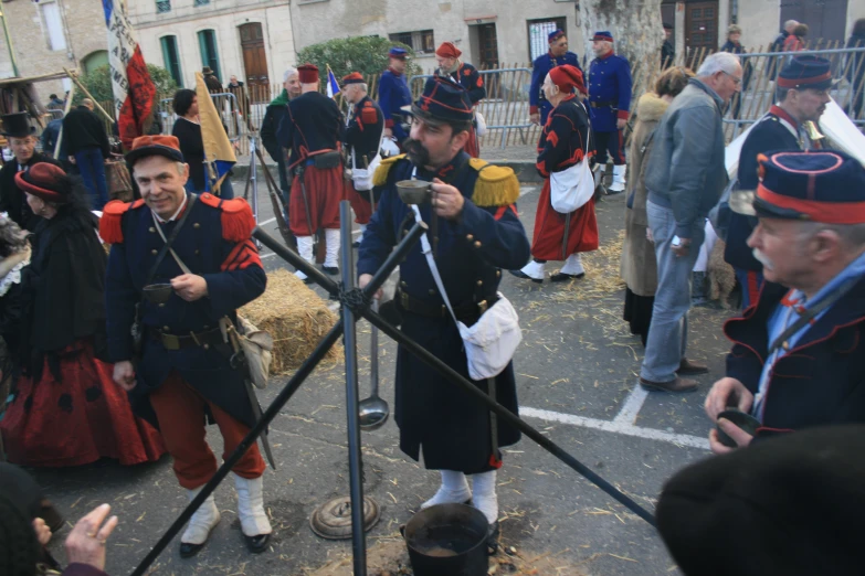 two men in red and black military uniforms holding swords