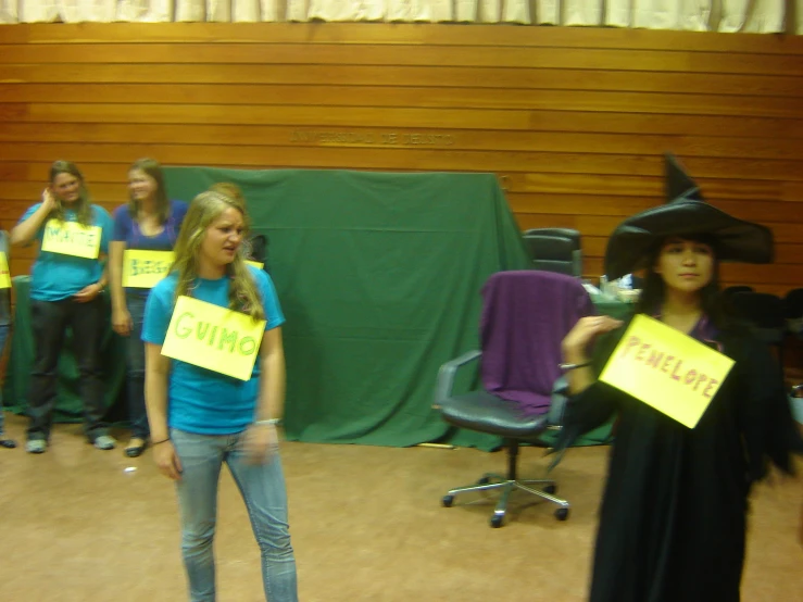 a group of women holding signs while wearing halloween costumes