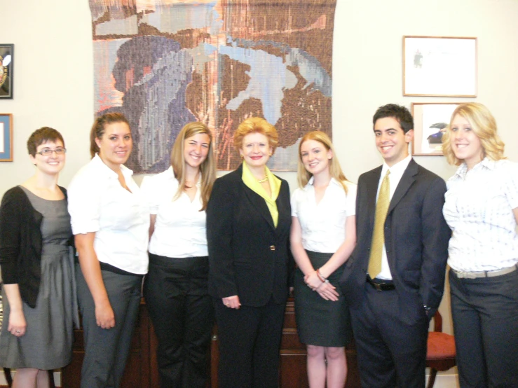 group of young and old professionals in suits pose for pograph