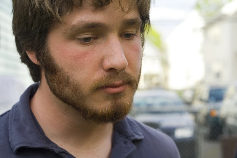 a close up of a young man with his hair styled to sideburn