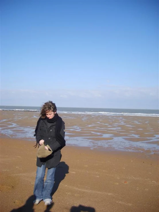 a person on a beach with a hat