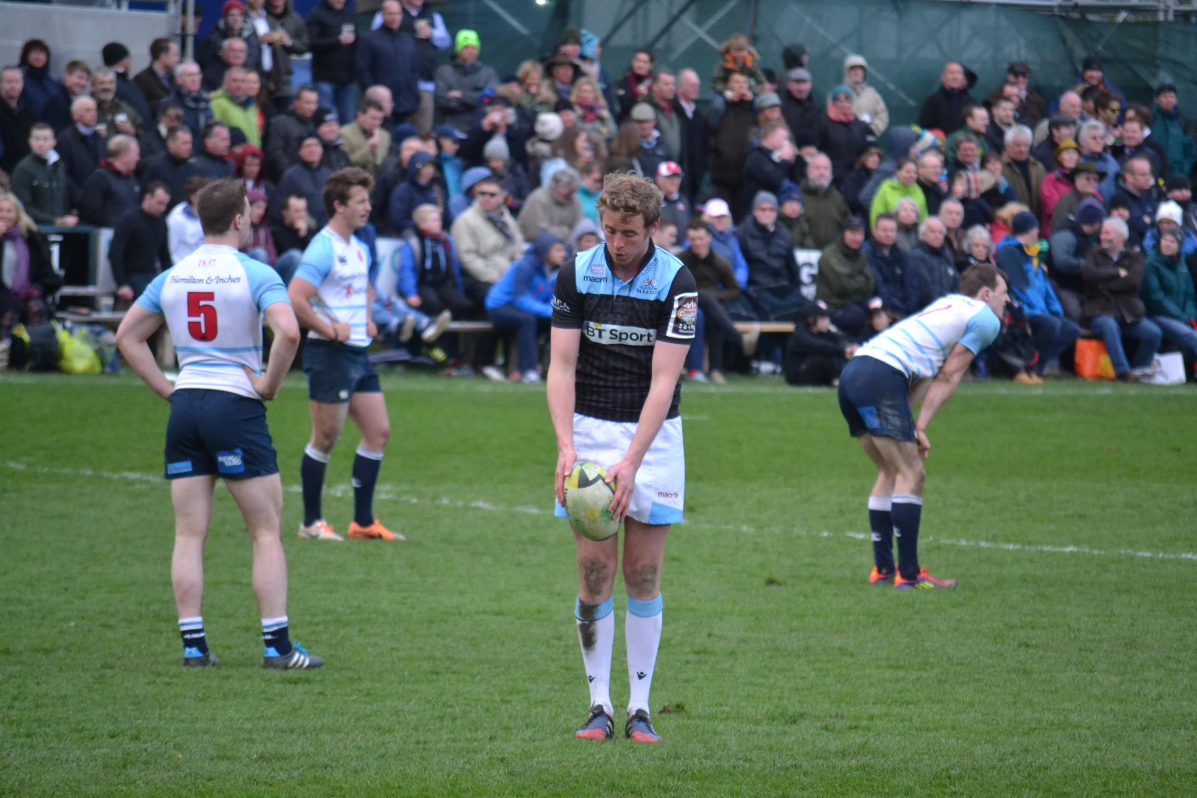 a man is holding a soccer ball near other players