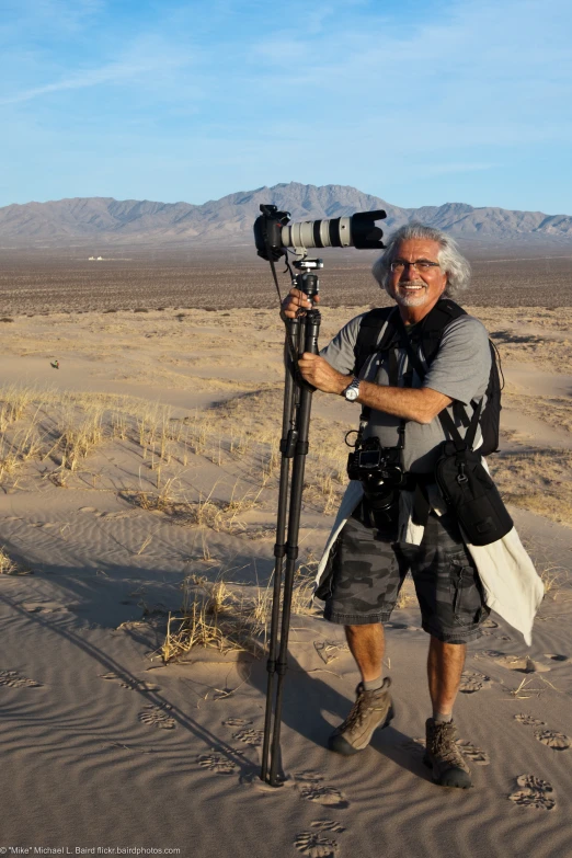 a man standing in the desert taking pictures