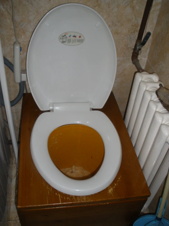 an open toilet bowl sitting on top of a wooden cabinet