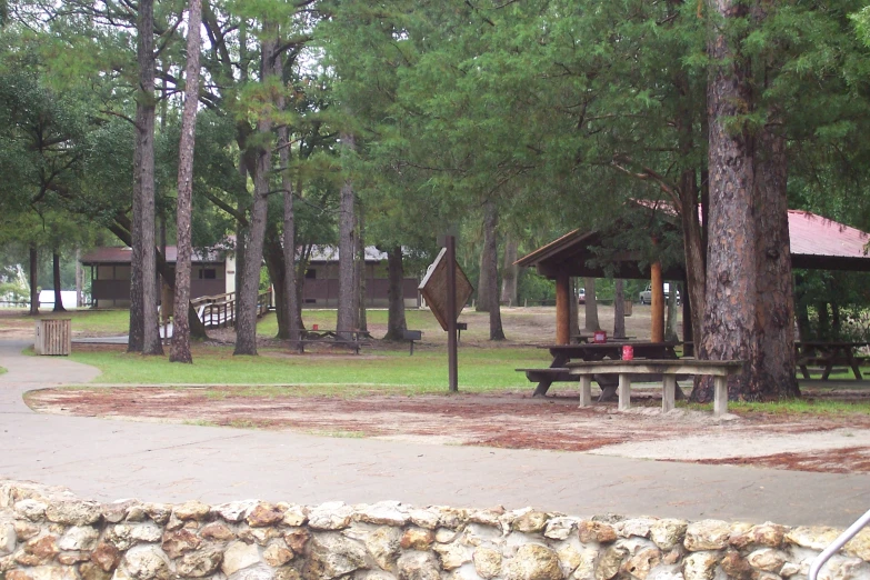 a park with a playground, picnic bench, and picnic tables