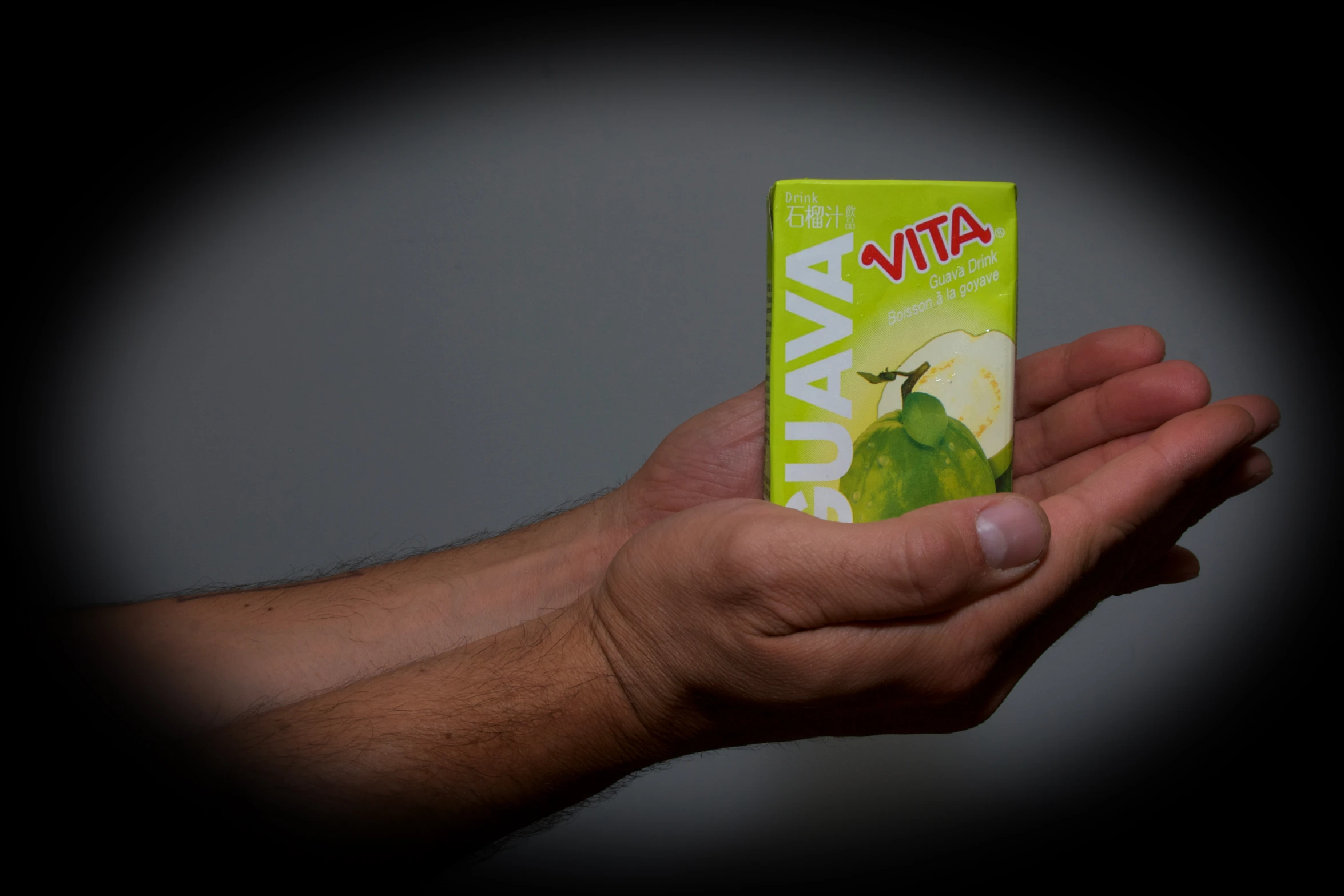 person holding out their small box of fruit