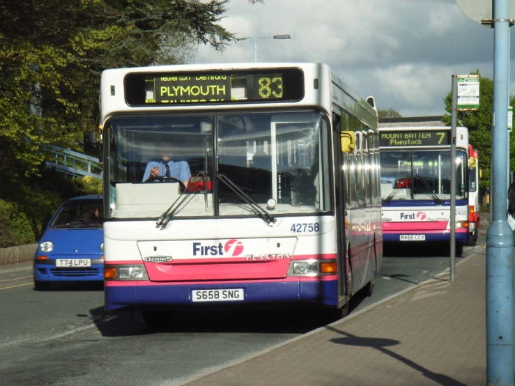 commuter buses are pulled up to the side of the road