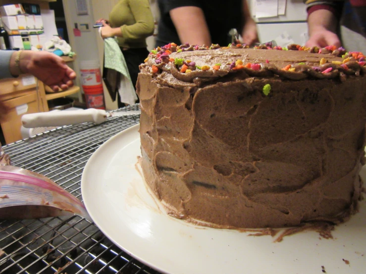 people are gathered around a table with a cake