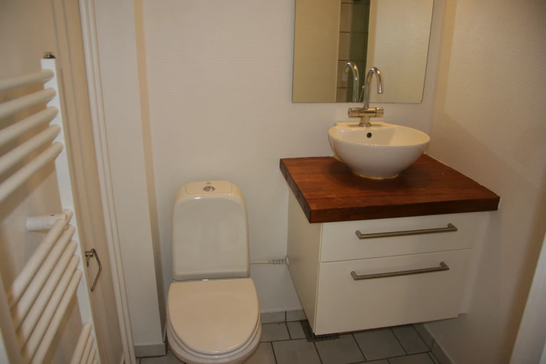 a sink and toilet in a small white bathroom