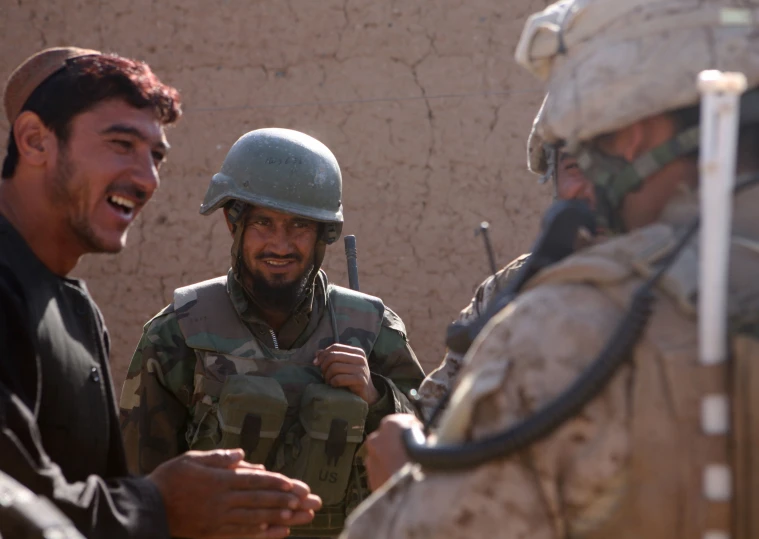 three men smiling and wearing helmets while holding soing