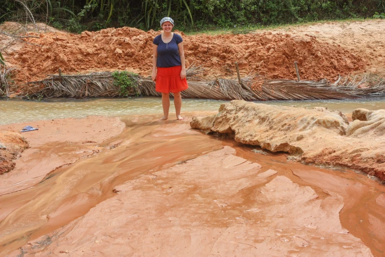 a woman posing for a picture at a riverbed