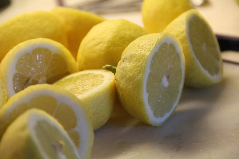 a pile of yellow lemons are being cut up