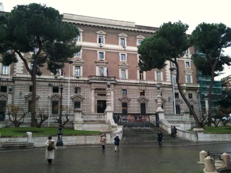 some people are walking in front of a large building