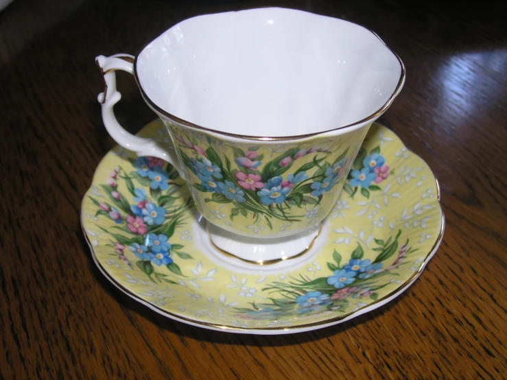 an empty cup on a plate with flowers