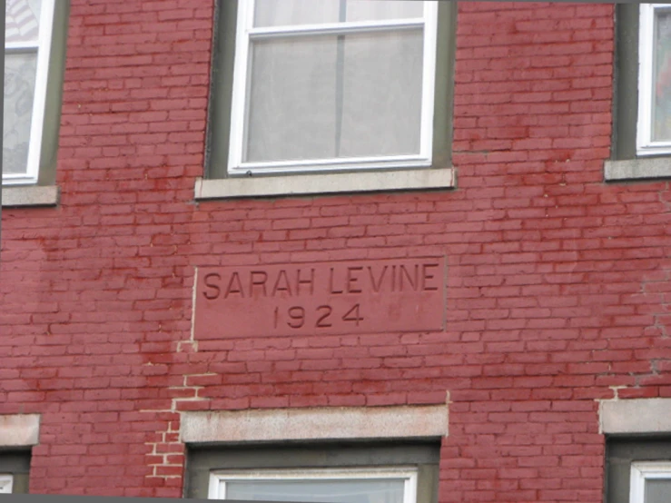 a brick building with graffiti that says sarahel leavevine