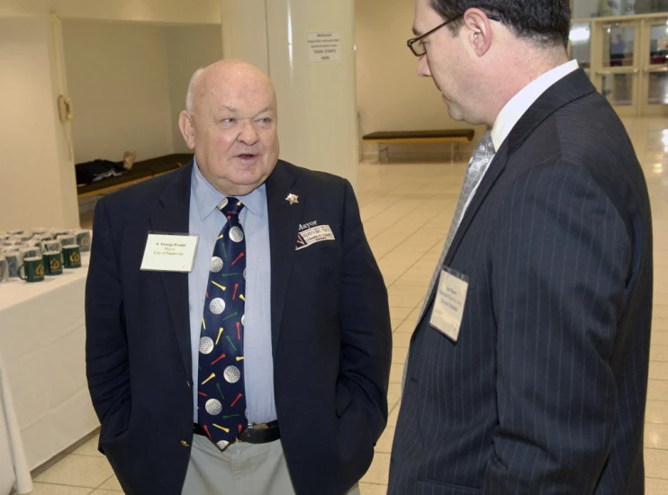 two men standing next to each other talking