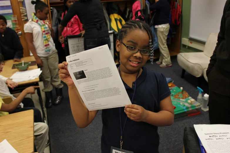 girl is holding up a certificate in front of the camera