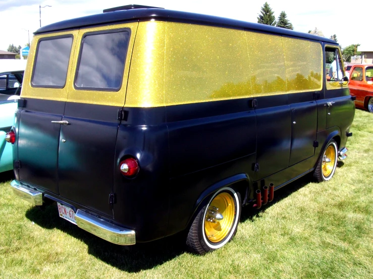 an old vehicle parked near other classic cars on grass