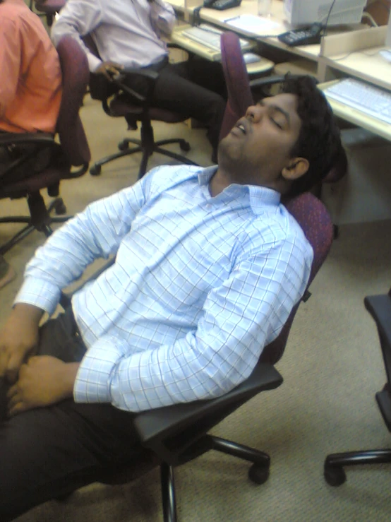 a man lays in an office chair with his feet up