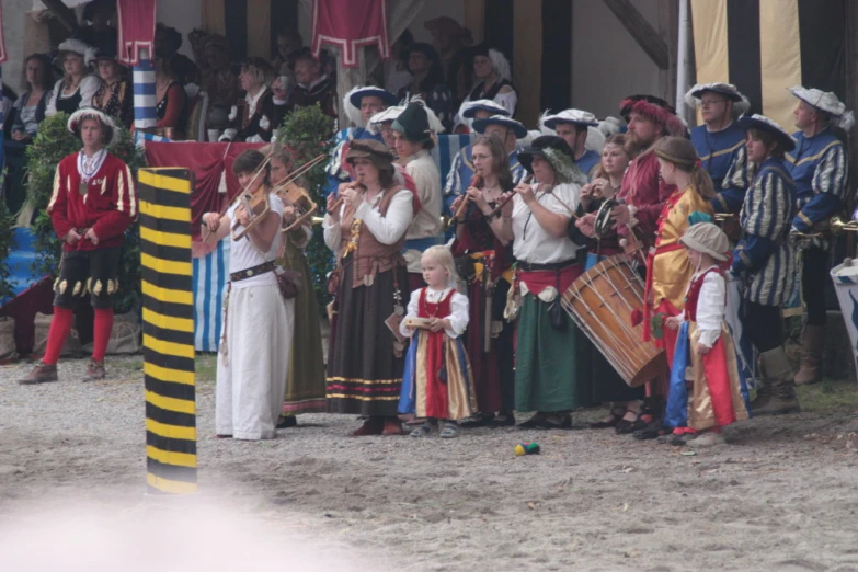 a small group of people wearing costumes in front of an audience