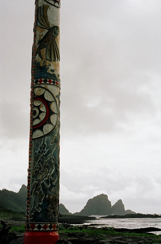 a totem pole at the end of a rocky beach