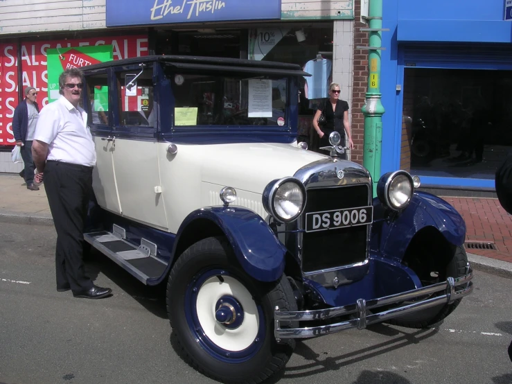 the man is standing beside his classic truck