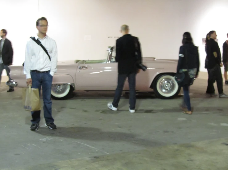 a person standing near a car in an auto show