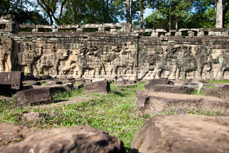 a large stone structure on the grass near rocks