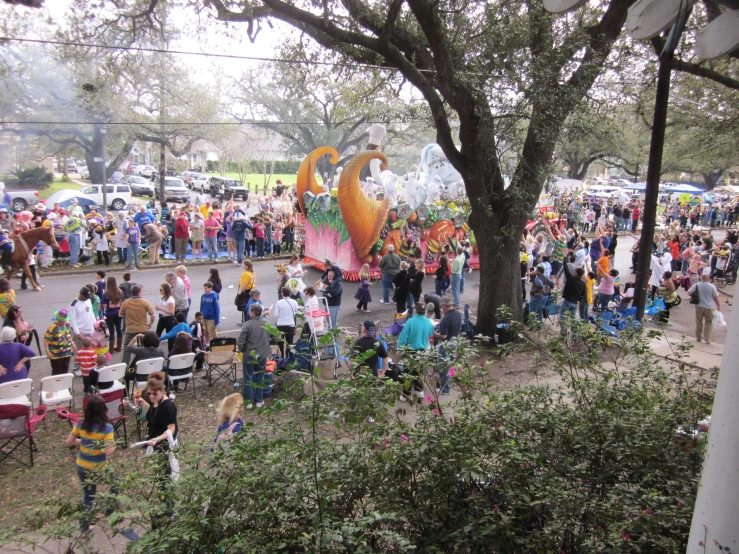 people attending a parade in the park, lined with chairs