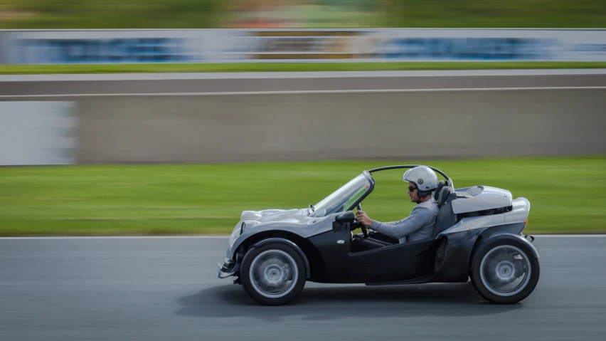 the man is riding in a two wheeled car