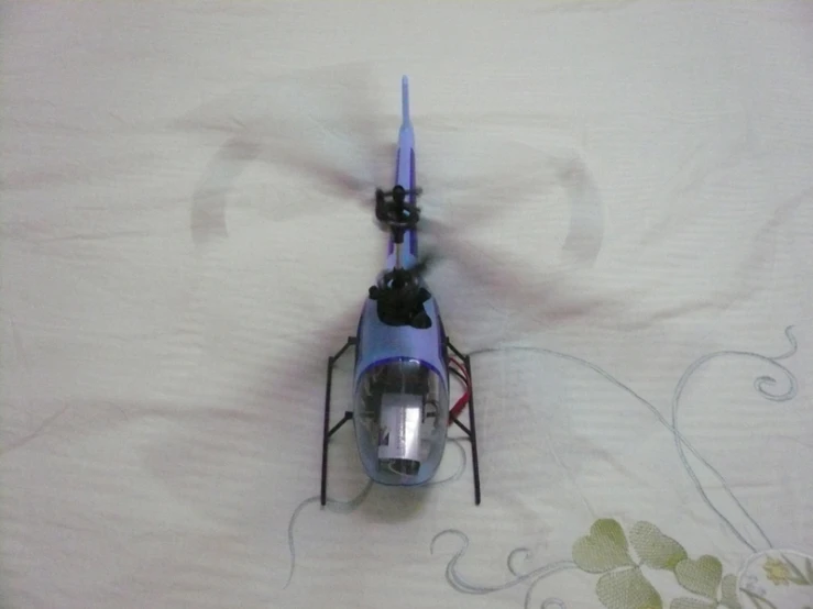 a small blue helicopter with some wires in it