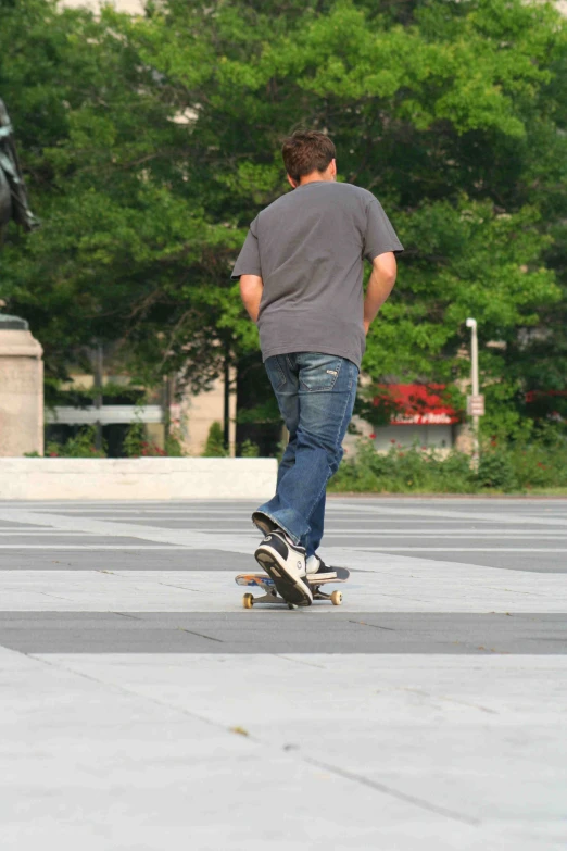 a person riding a skate board on a paved area