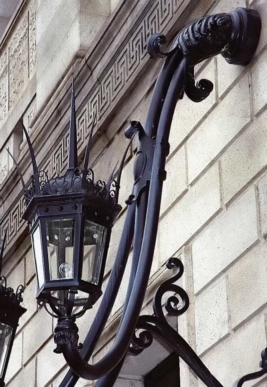 an old fashioned lamp post stands next to a building