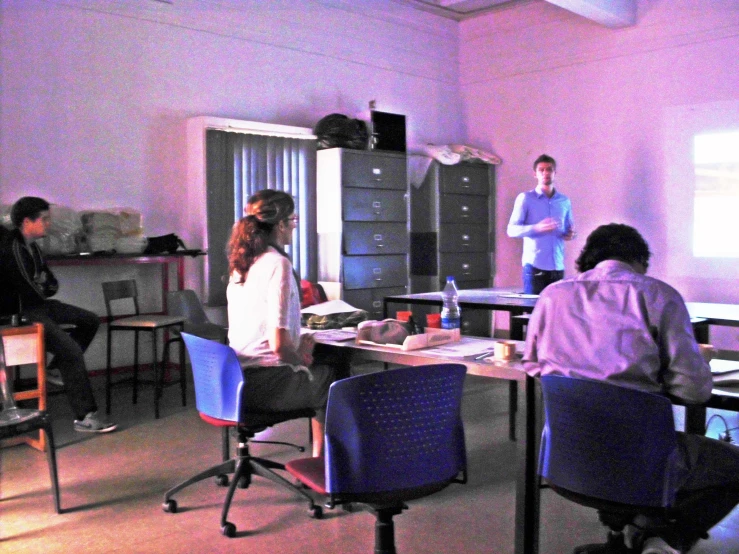 a group of people in a room with desks