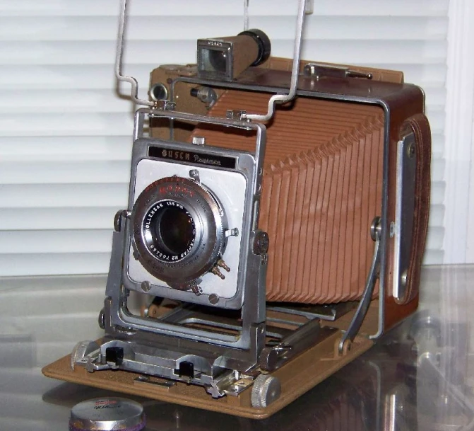 an old fashioned camera sitting on top of a wooden box