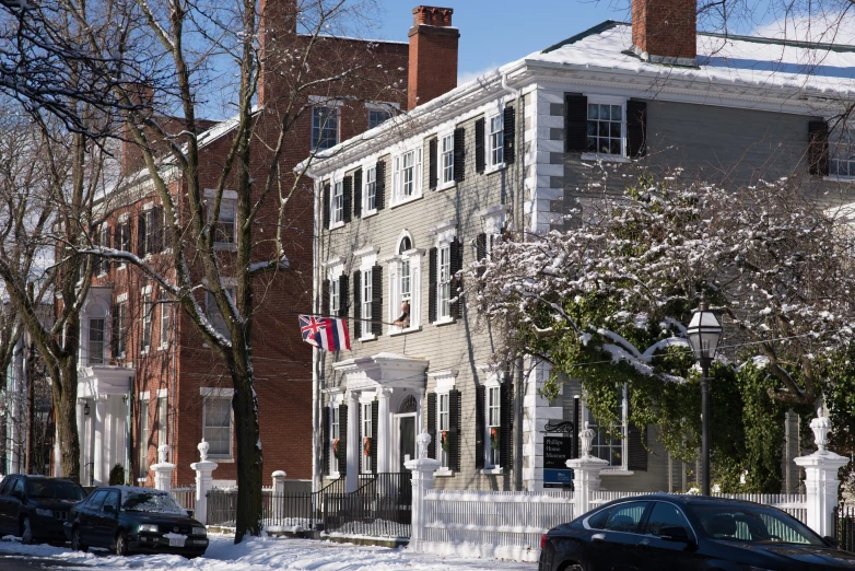a large white house covered in snow next to buildings